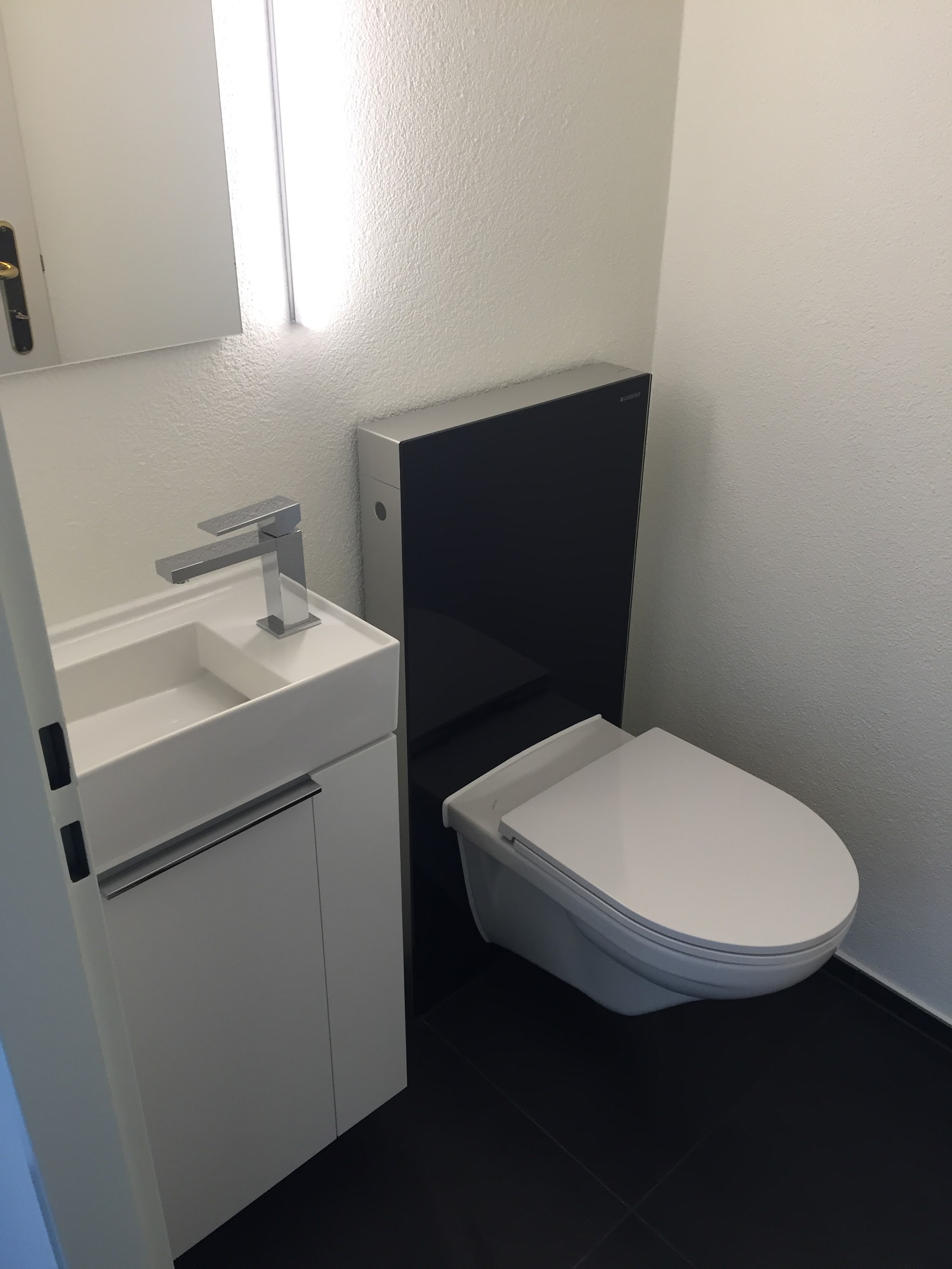 Fertig installiertes Gäste-WC mit Wand-WC und Waschtisch